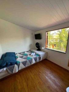 um quarto com uma cama num quarto com uma janela em Sua casa na praia em Caucaia