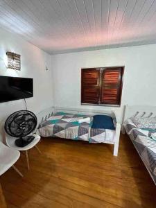 a bedroom with two beds and a television in it at Sua casa na praia in Caucaia