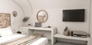 a white bedroom with a bed and a tv at Afora Houses in Vóthon