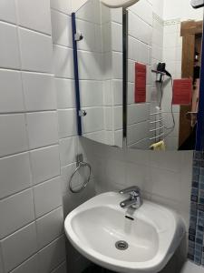 a white bathroom with a sink and a mirror at Sultanias Homesharing in Nuremberg