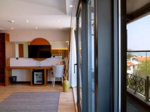 a living room with a view of a kitchen and a balcony at Maison Vourla Hotel in Urla