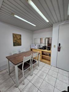 uma sala de jantar com mesa e cadeiras e uma cozinha em IKA Apart Hotel em Brasília