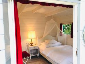 a bedroom with a white bed with a canopy at Teichhäuschen Cyprinus in Aarau