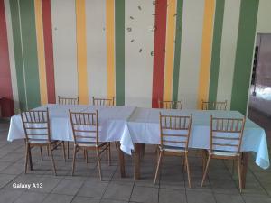 stół z 4 krzesłami i białą ściereczką w obiekcie Princess Hotel T/A Epic Hotel ,Oshikango w mieście Oshikango