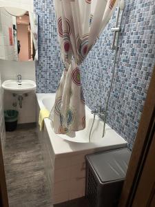 y baño con cortina de ducha y lavamanos. en Sultanias Homesharing, en Núremberg