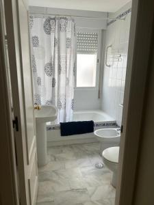 y baño con aseo, lavabo y ducha. en APARTAMENTO EDIFICIO SEVILLA II, en Jerez de la Frontera