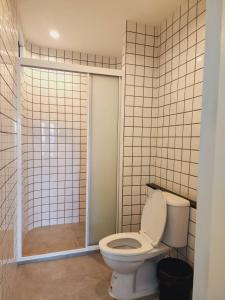 a bathroom with a toilet and a glass shower at Line Bangkok Hostel in Bangkok