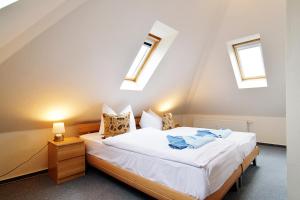 a bedroom with a bed and two windows at FeWo Ahoi - 73 qm maritime Gemütlichkeit auf zwei Ebenen in Ostseebad Koserow