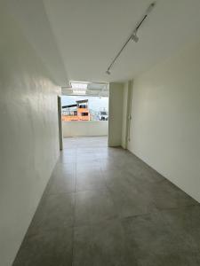 Habitación vacía con paredes blancas y suelo de baldosa. en Line Bangkok Hostel en Bangkok