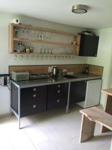eine Küche mit einer Theke mit einem Herd und einer Spüle in der Unterkunft RamsAu-das Gasthaus in Bad Heilbrunn