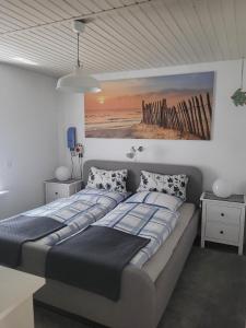 a bedroom with two beds and a painting on the wall at Ferienbungalow FeWo Eutin Süsel Sierksdorf Strand Ostsee in Süsel