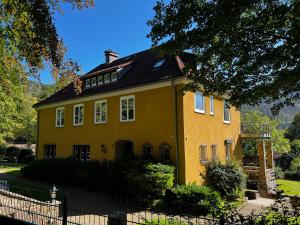 a yellow house with a black roof at Villa Mara in Bad Lauterberg