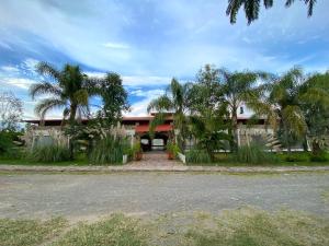 a house with palm trees in front of it at Frutos Hotel in Ameca