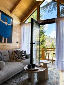 Kuća na drvetu - Zlatar Hill - Treehouse في نوفا فاروس: غرفة معيشة مع أريكة ونافذة كبيرة