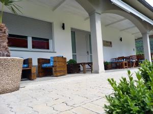 a patio with wooden furniture and a building at B&B Il Crocevia in Teglio