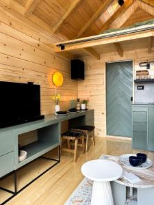 Kuća na drvetu - Zlatar Hill - Treehouse في نوفا فاروس: غرفة معيشة مع تلفزيون وطاولة