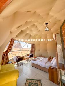 a bedroom with a large bed and a large window at Rum Laverne Luxury Camp in Wadi Rum