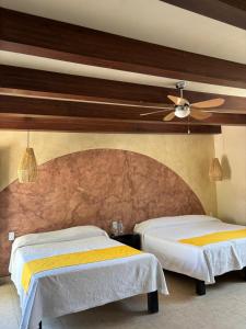 a bedroom with two beds and a ceiling fan at Frutos Hotel in Ameca