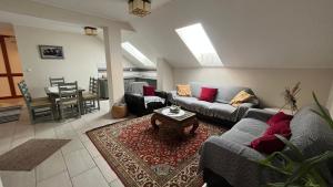 a living room with two couches and a table at Bozsity Vendégház in Üllés