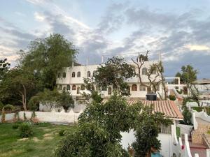 a large white building with trees in front of it at Casa de Campo - Fundo Raquel in Ica