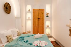 Un dormitorio con una cama con almohadas encima. en Riad Mama, en Marrakech