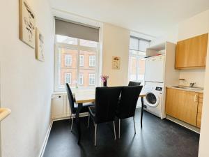 uma cozinha e sala de jantar com mesa e cadeiras em aday - Randers cozy 1 bedroom apartment em Randers