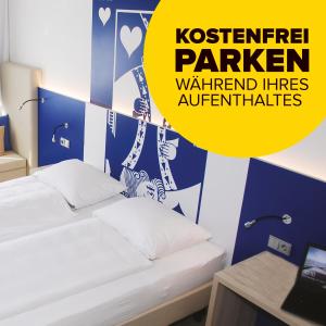 a bedroom with two beds and a yellow sign at IBB Hotel Paderborn in Paderborn