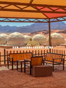 un grupo de bancos sentados bajo un paraguas en el desierto en Rum Laverne Luxury Camp en Wadi Rum