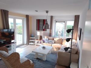 a living room with a couch and a table at Villa-Meerchen-Villa-mit-ueberdachter-Terrasse-800m-vom-Strand-entfernt in Kamperland
