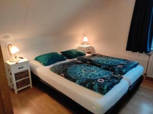 a bed with two pillows on it in a room at Villa-Meerchen-Villa-mit-ueberdachter-Terrasse-800m-vom-Strand-entfernt in Kamperland