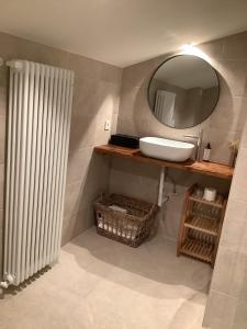 a bathroom with a sink and a mirror and a radiator at Hotel Finca La Mixtura, Restaurant Mélange in Ontinyent