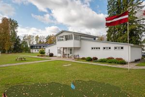 a house with a canadian flag in the yard at Staicele - Learning and Training Hub in Staicele