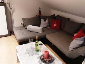 a living room with a couch and a table with wine glasses at Ferienwohnung Schöner in Oberharmersbach