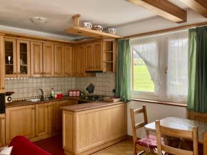 a kitchen with wooden cabinets and a table and a window at Villa Iris Asiago - giardino e parcheggio in Asiago