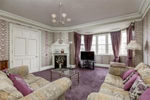 a living room with a couch and a tv at Flat on Ramsay in Edinburgh