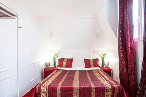 - une chambre avec un lit et une couverture rouge dans l'établissement Appartement Unique à 13 min de Paris, à Deuil-la-Barre