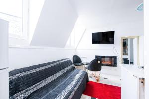 - une chambre blanche avec un lit et une cheminée dans l'établissement Appartement Unique à 13 min de Paris, à Deuil-la-Barre