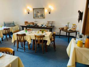 a dining room with tables with yellow tablecloths at Hotel Wendelstein in Rosenheim