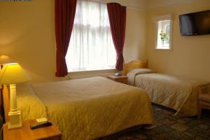a hotel room with two beds and a window at Gatwick Turret Guest House in Horley