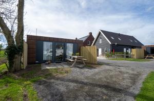 a house with a picnic table in front of it at B&B/Tiny House Bij Zee in Stellendam