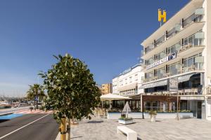 un gran edificio con un árbol delante en Hotel Ampolla Sol, en L'Ampolla