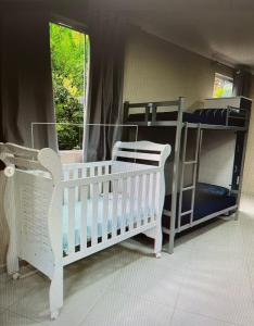 Nostra Cuesta Hostel في بوتوكاتو: سريرين بطابقين وسرير أطفال في غرفة