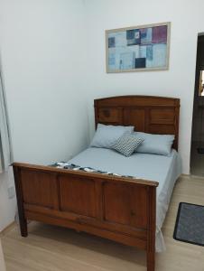 Nostra Cuesta Hostel في بوتوكاتو: سرير مع اطار خشبي في الغرفة