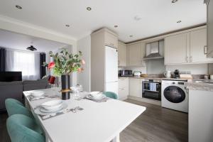 uma cozinha com uma mesa branca com um vaso de flores em Romsey Terrace-3 Bedroom House with parking em Cambridge