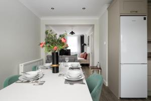 uma cozinha e sala de estar com uma mesa branca e cadeiras em Romsey Terrace-3 Bedroom House with parking em Cambridge