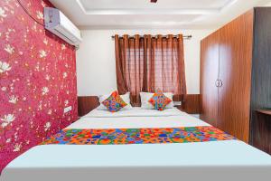バンガロールにあるFabExpress Symphony Suitesのベッドルーム1室(赤いカーテン付きの大型ベッド1台付)
