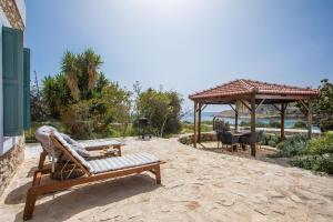 a patio with a bench and a gazebo at Lady Stamatias House in Halki