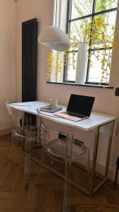 a white table with a laptop on top of it at The Annexe in Stockport