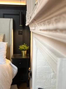um quarto com uma cama e uma lareira branca em The Annexe em Stockport