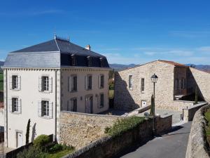 a large white building with a turret next to a wall at The View - Gite Sancy in Montpeyroux